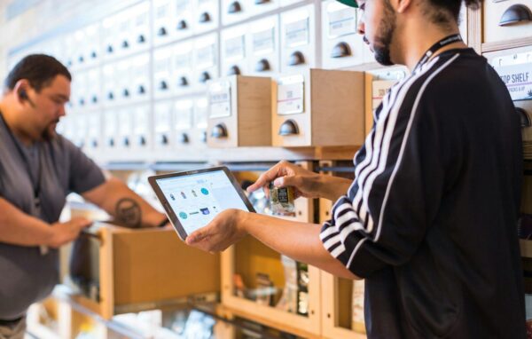 Photo by Cova Software two men in a store looking at a tablet